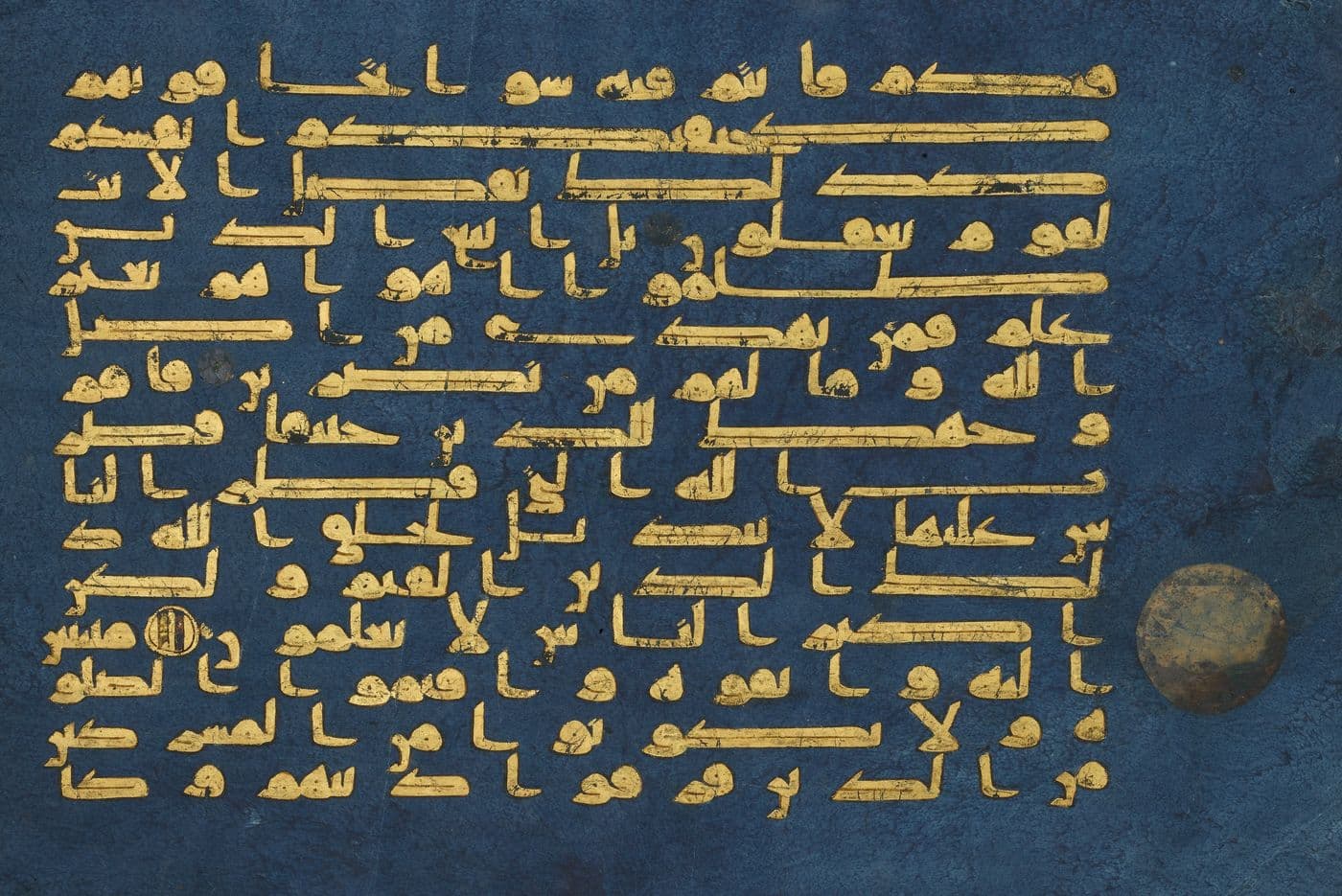 A page of the Blue Qur'an: Kufic script in gold on indigo-dyed parchment.